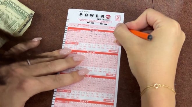 A player fills out a Powerball play slip while preparing or checking tickets for the June 10, 2026 drawing.