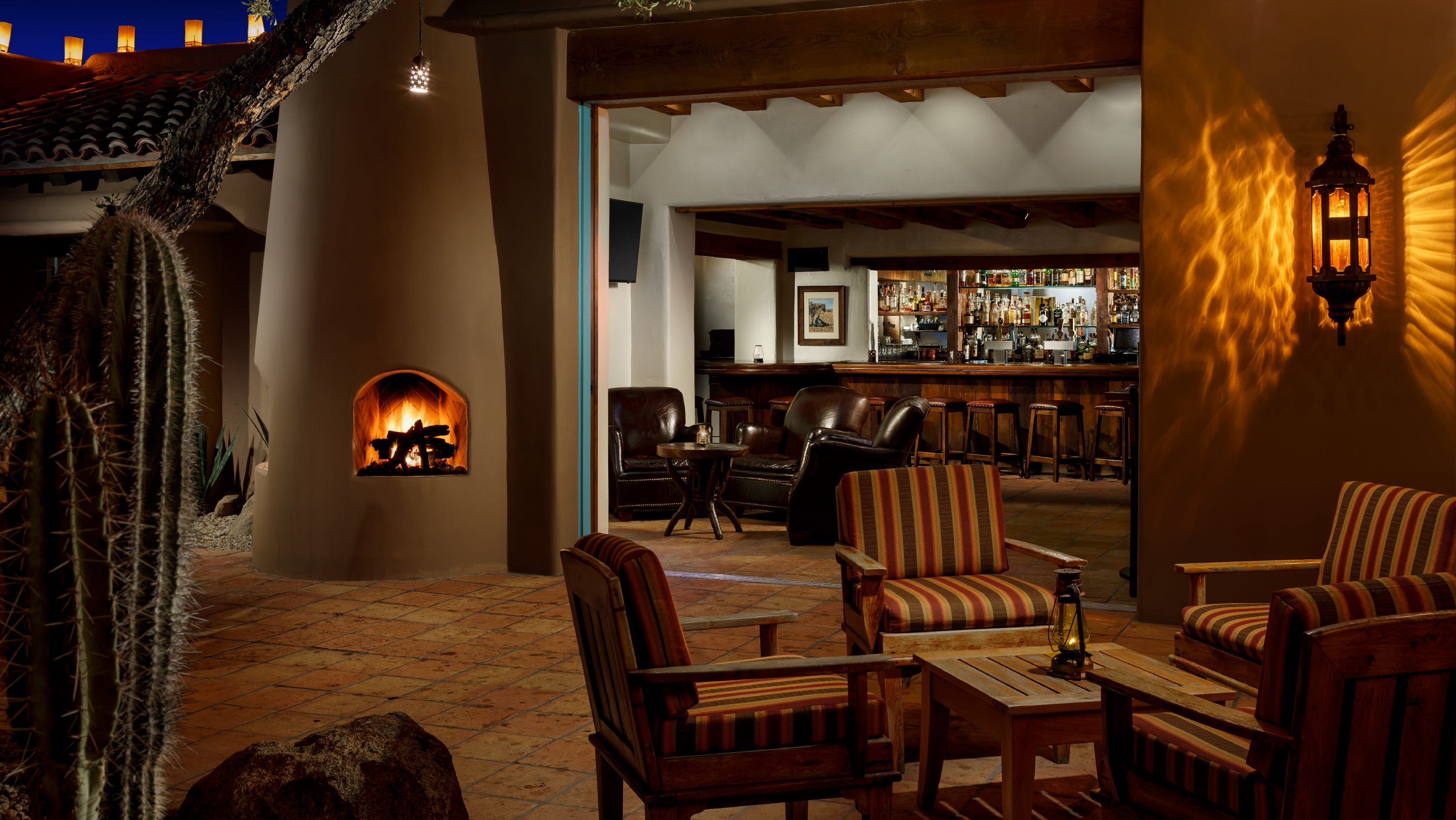 Interior lounge and bar at the historic Arizona establishment — leather seating, a lit fireplace and the wood bar — illustrating the venue honored on Esquire’s list.
