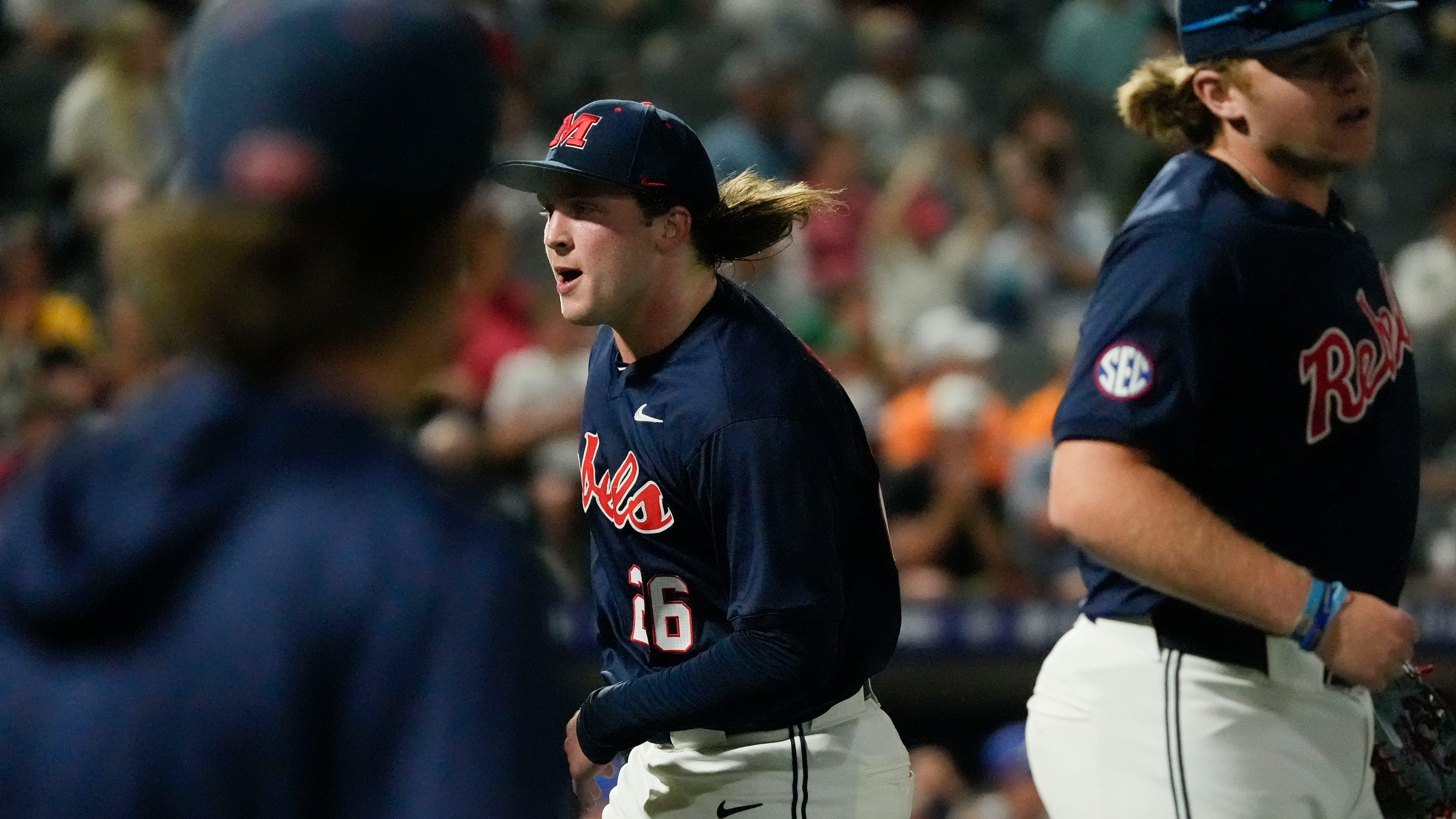 An Ole Miss player moves toward the dugout amid postgame celebration following the Rebels' 10th‑inning walk‑off victory over Arizona State.