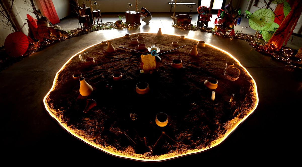 A circular installation of pottery and illuminated sand on display inside the community center, showcasing an art project supported by the center’s neighborhood cultural initiatives.