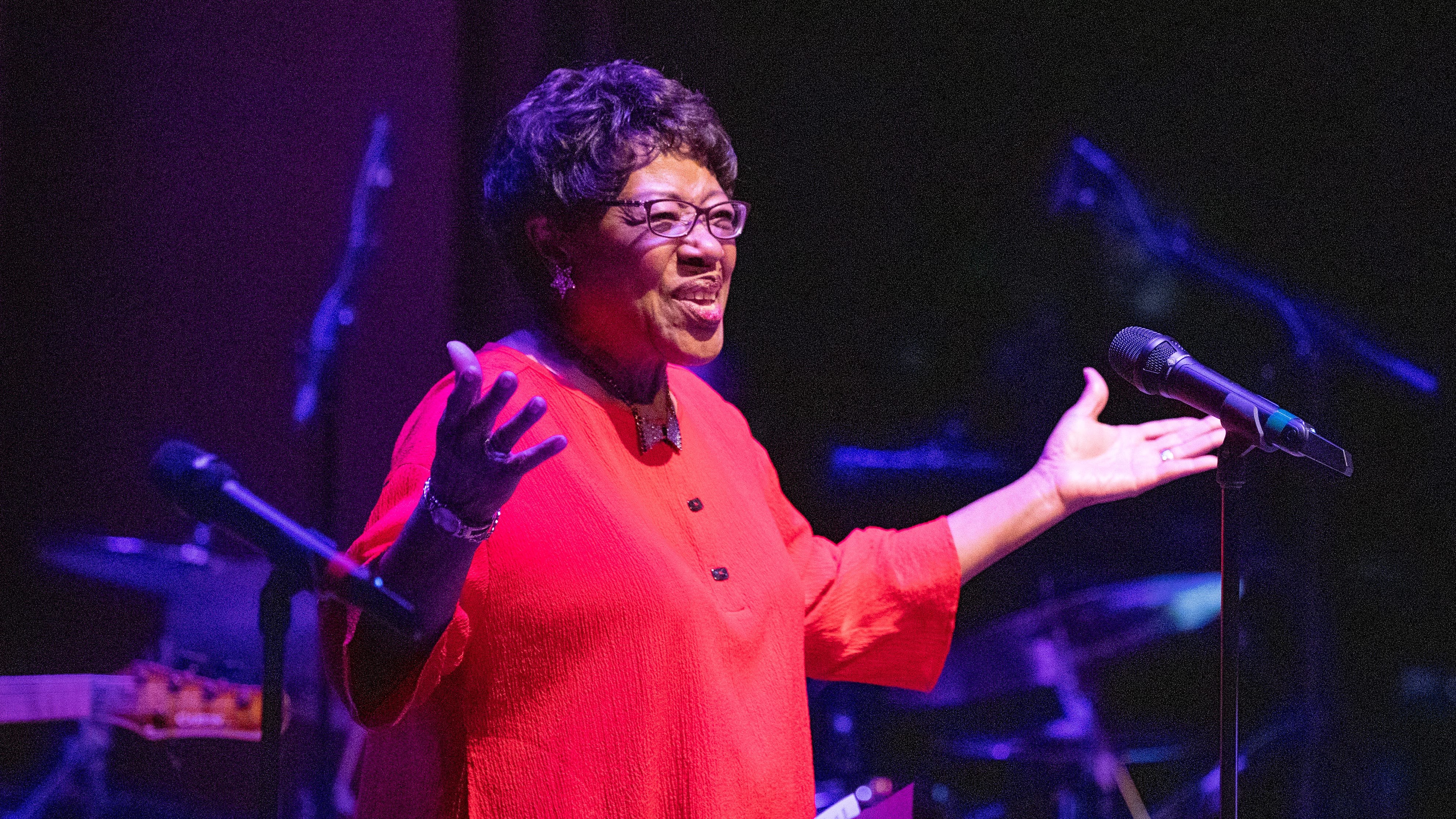 A singer performs onstage, illustrating the live concerts that draw crowds to the century‑old Nile Theater.