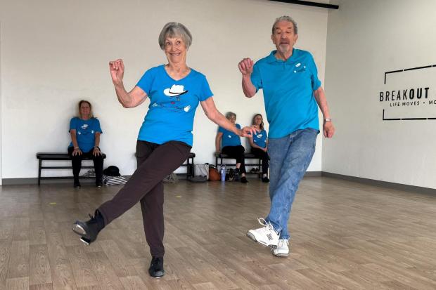 A troupe member and her partner perform steps during practice at a Tucson studio, highlighting long-term engagement in dance among older adults.