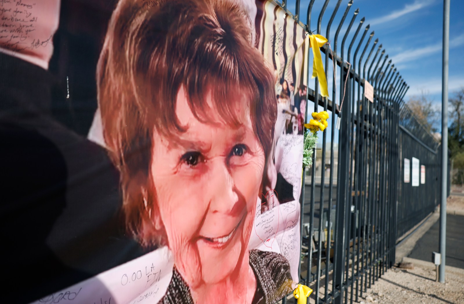 A large memorial banner with a portrait of the missing 84-year-old is tied to a fence in Tucson, where investigators continue to probe the case.