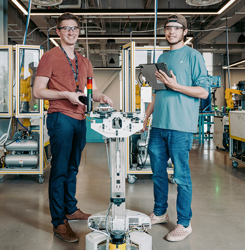 Students use automation equipment and a tablet in a community‑college lab as part of Arizona’s ReadyTechGo industrial manufacturing training initiative.
