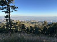 View from the Mt. Lemmon area looking toward the valley near the Sycamore Fire, showing the terrain and distant haze from the fire.
