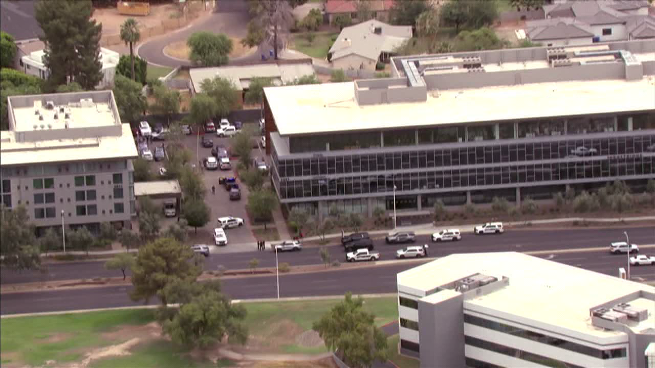 Aerial view of office buildings and parked police vehicles along a street in central Phoenix as authorities respond to a DPS detective-involved shooting.