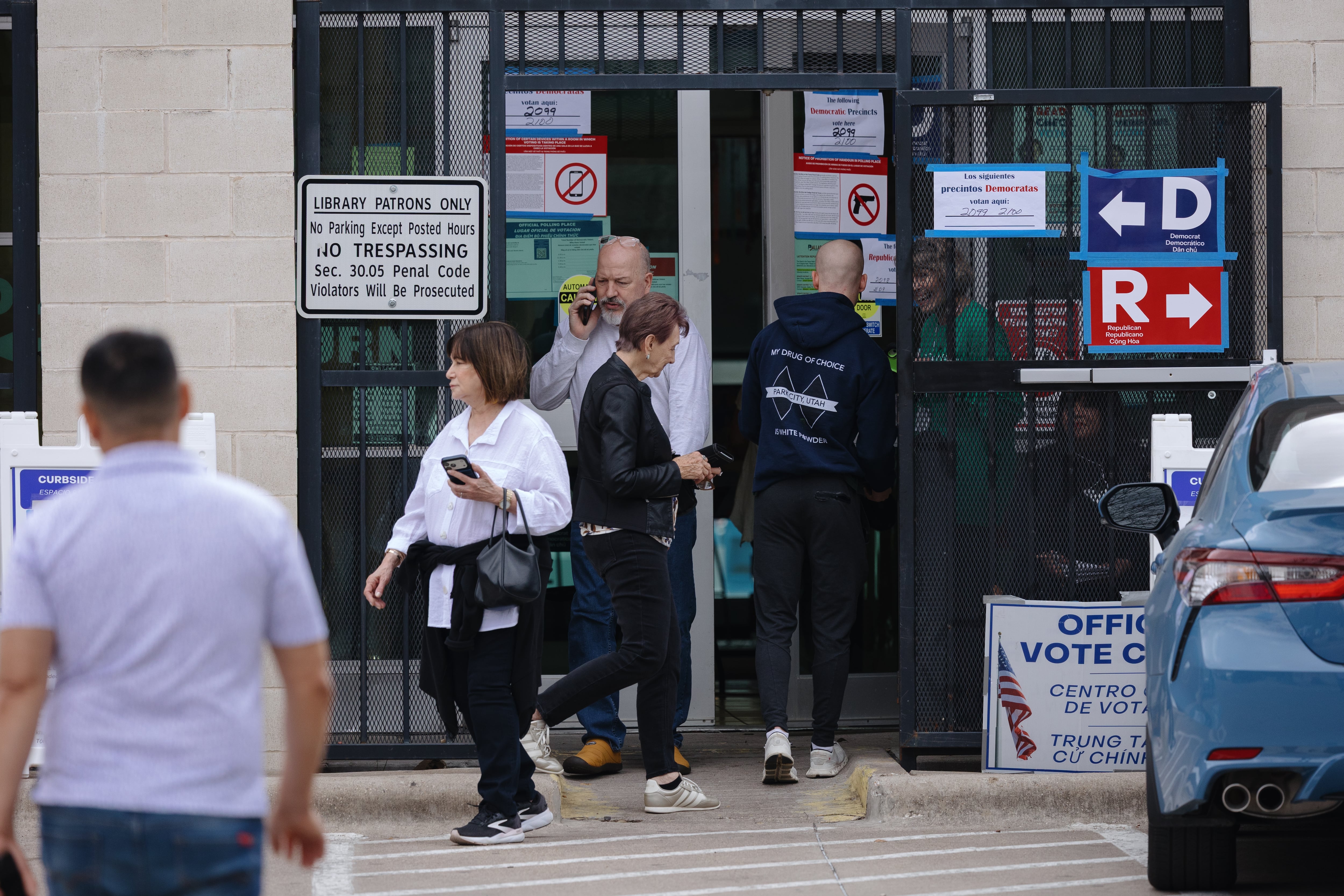 Voters enter a polling site marked with Democratic and Republican precinct signs; the legal challenge in the story concerns the eligibility of Navajo County’s new recorder, who oversees local elections.
