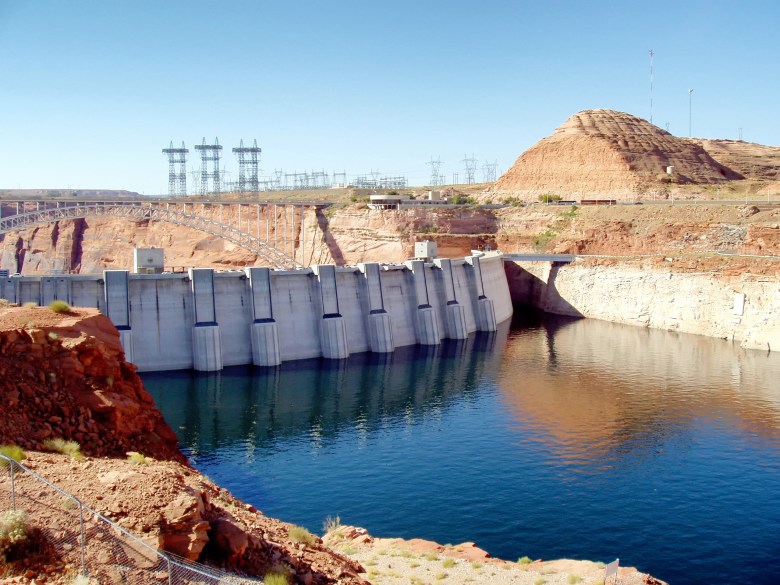 Dam infrastructure and exposed shoreline on the Colorado River, illustrating shrinking reservoir storage and the stakes for Arizona as interstate negotiations over water allocations remain deadlocked.