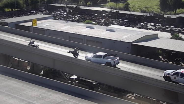 Aerial view of the Loop 101 to Loop 202 transition ramp showing a crashed motorcycle, a pickup truck and emergency presence as authorities work the scene during the ramp closure.