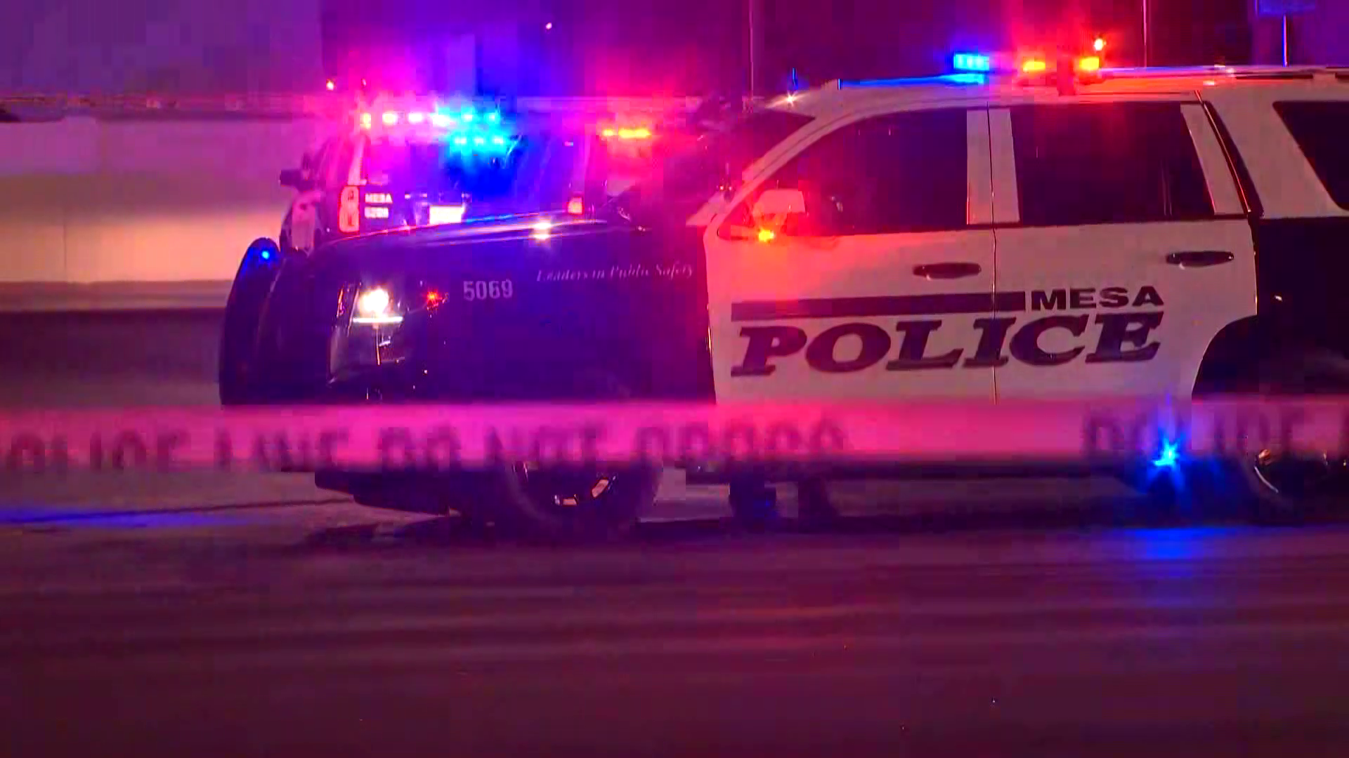 Police SUVs with flashing lights and police tape — representing law enforcement stepping up patrols and citations related to illegal fireworks in the Phoenix area.
