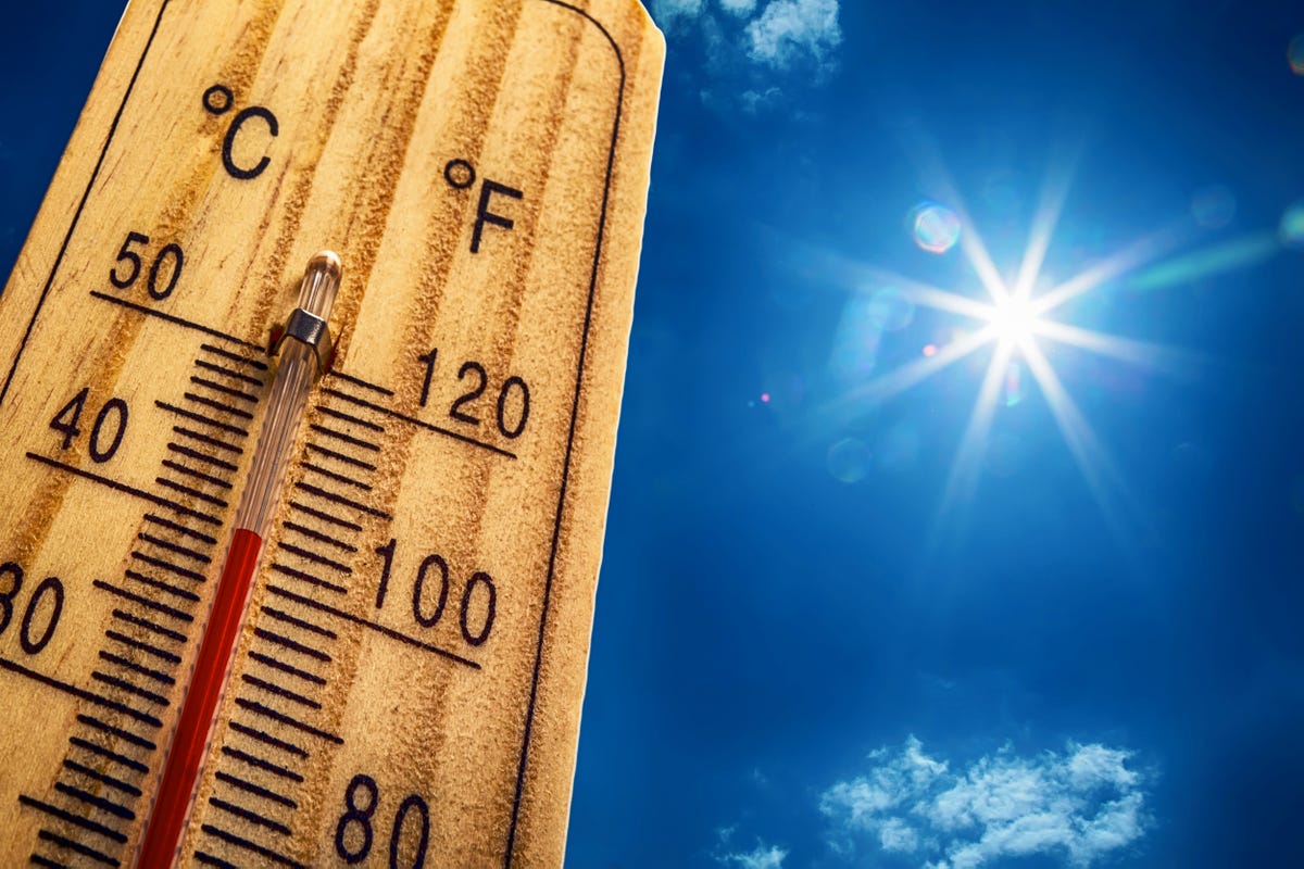 A thermometer against a bright sun, underscoring the extreme heat Arizona residents face when weighing whether cracking a garage door helps cool a home.