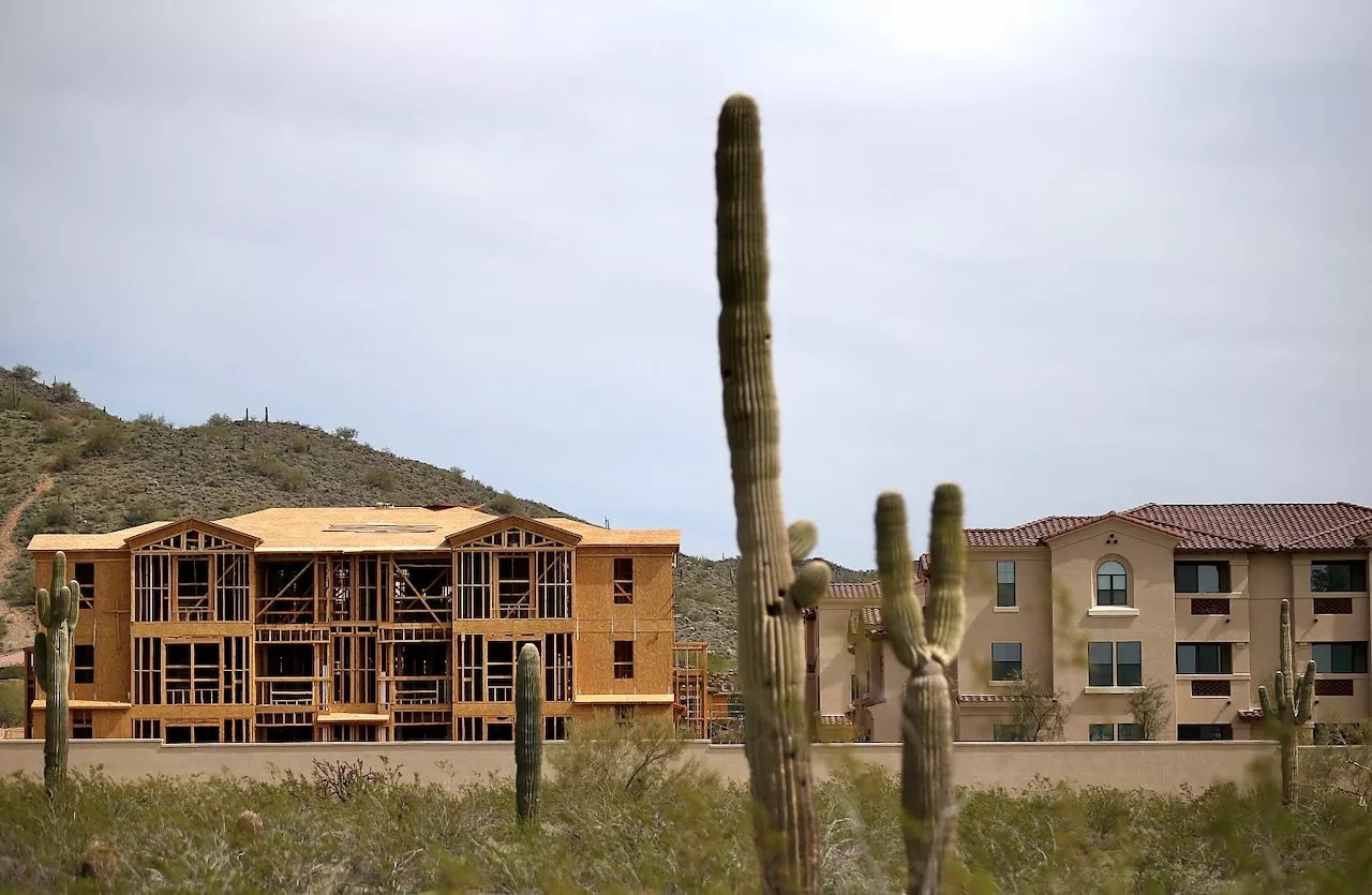 New residential construction with saguaro cacti in the foreground on the outskirts of Phoenix, illustrating local housing development amid a shortage for middle‑income buyers.
