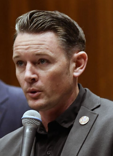 State lawmaker speaks into a microphone at the Capitol amid criticism over an anti‑abortion comment directed at a colleague.